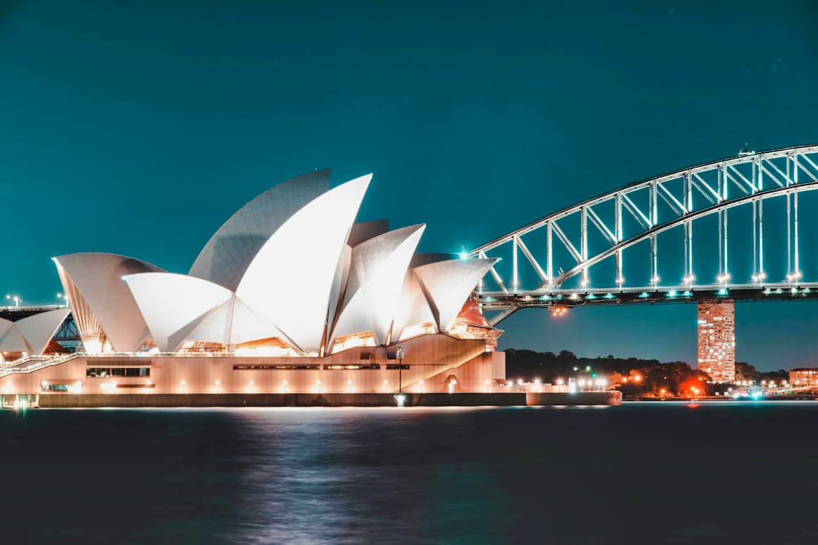 Iconic Sydney Opera House and Sydney Harbour Bridge at night, major landmarks in Australia.
