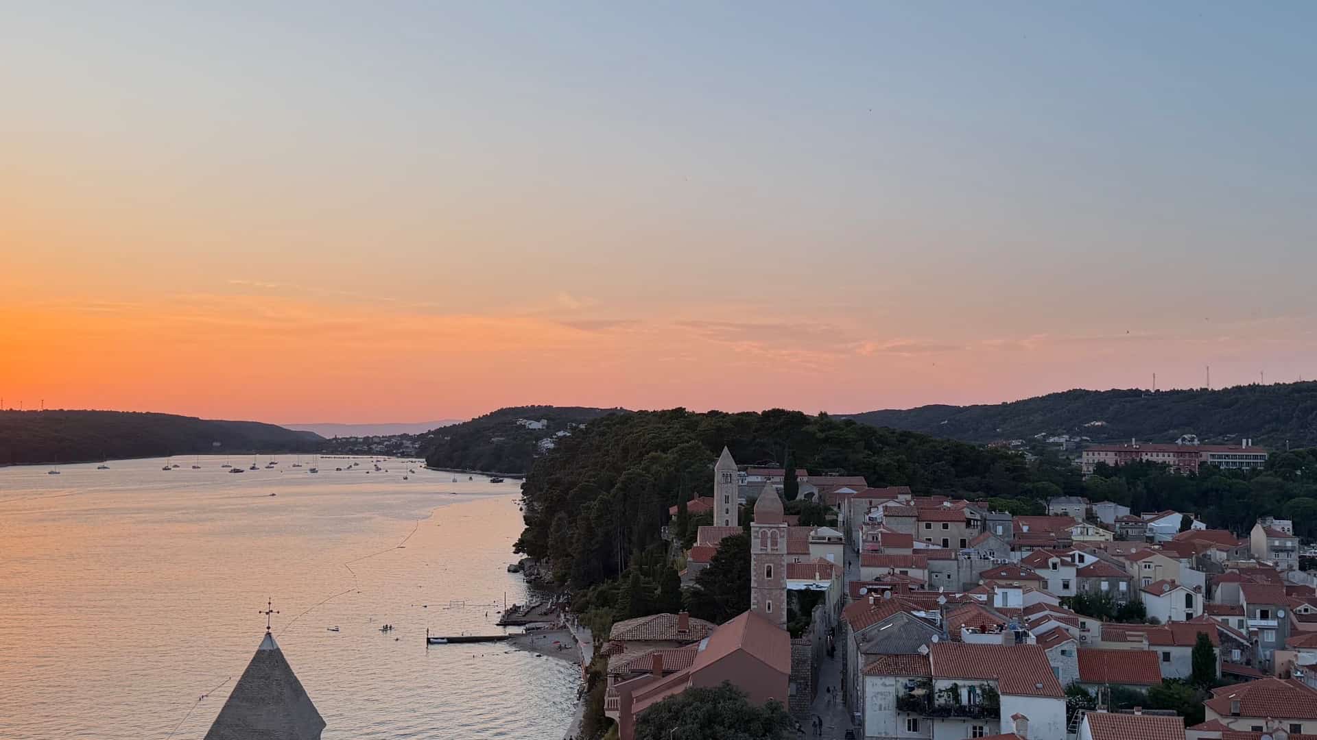 Golden hour panorama overlooking the terracotta roofs and coastal ridge of Rab Old Town.