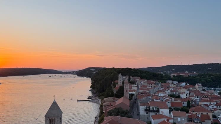 Golden hour panorama overlooking the terracotta roofs and coastal ridge of Rab Old Town.