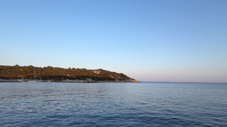 Clear blue waters of the Southern Dalmatian Channel framed by sailboat rigging near distant limestone hills.