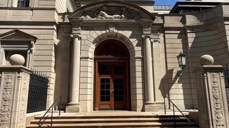 Grand limestone entrance facade and heavy wooden doors of The Frick Collection on Fifth Avenue.