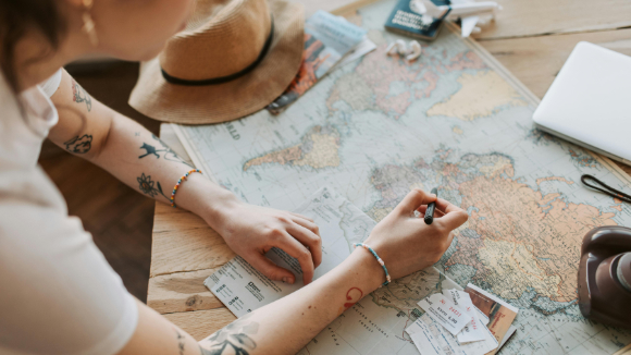 Person drawing a route on a map