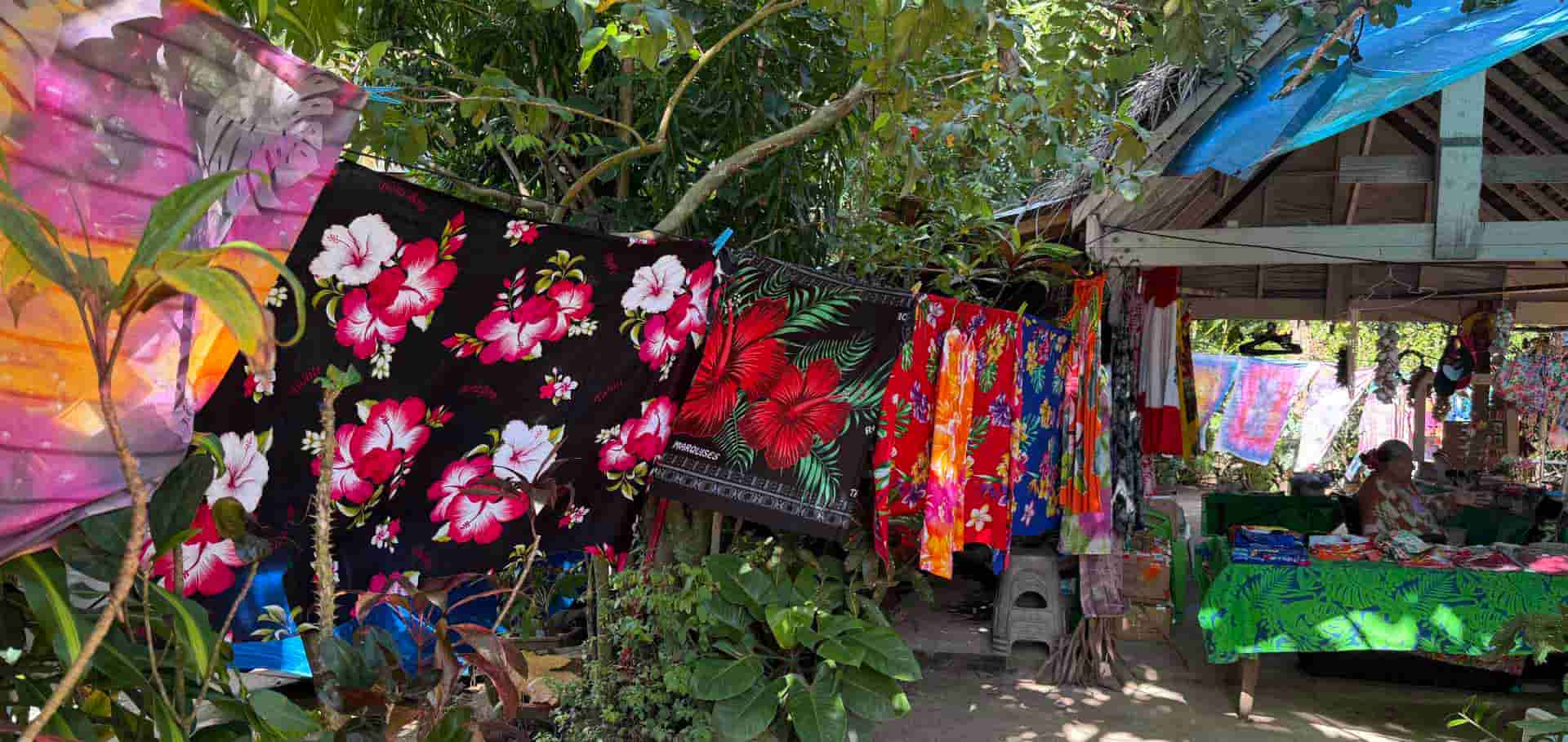 Vibrant floral pareos and clothing hanging on outdoor lines at a workshop in Bora Bora.