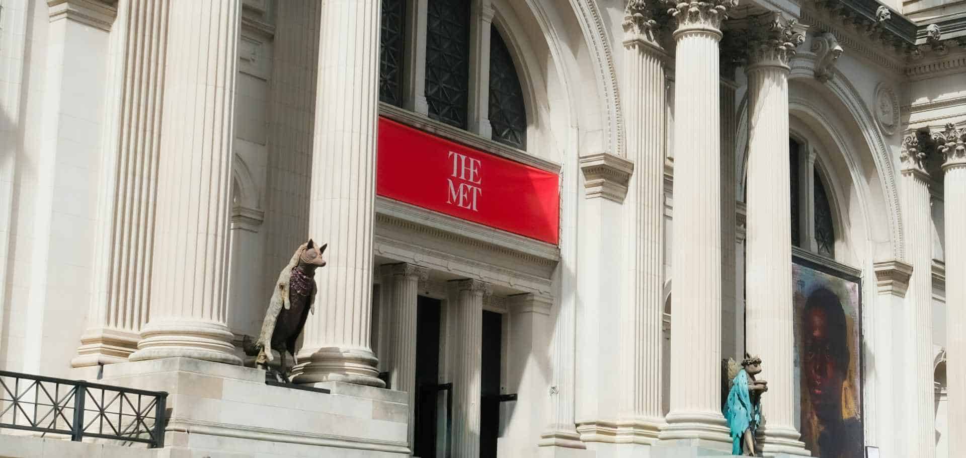 Grand neoclassical columns and red banners welcome visitors to the entrance of The Metropolitan Museum of Art