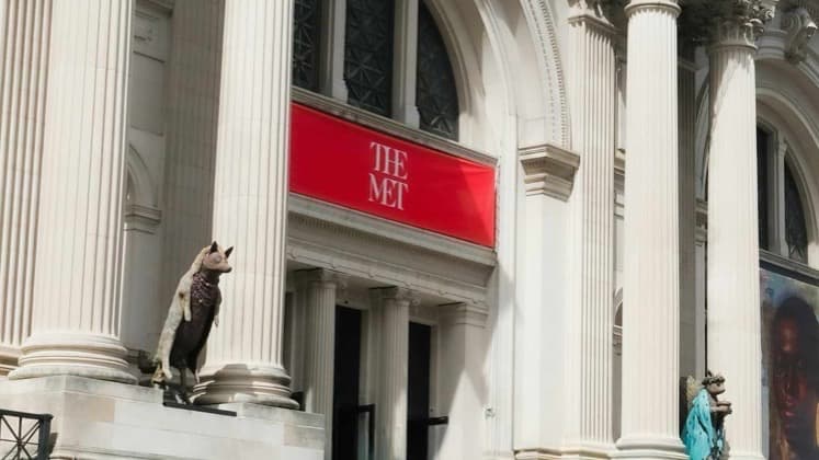 Grand neoclassical columns and red banners welcome visitors to the entrance of The Metropolitan Museum of Art
