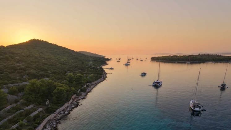 Sailboats anchored in a calm Croatian bay at sunset during an Adriatic voyage