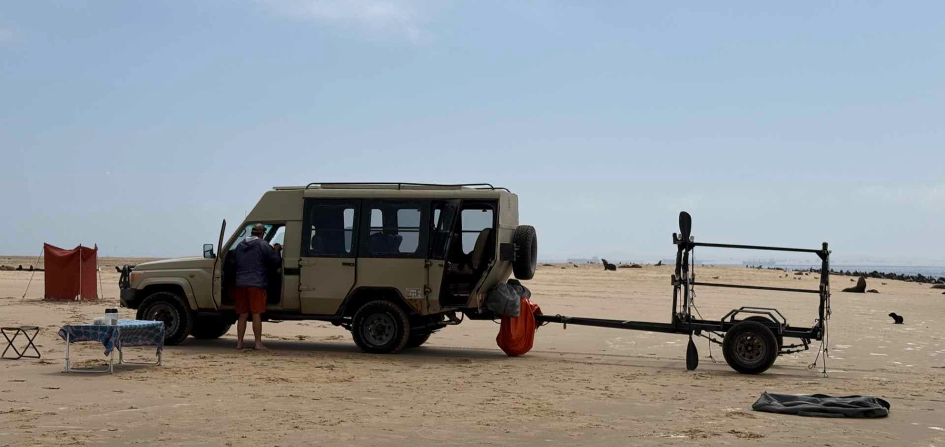 Off-road 4x4 pick up parked on a beach in Namibia with sea lion in the back