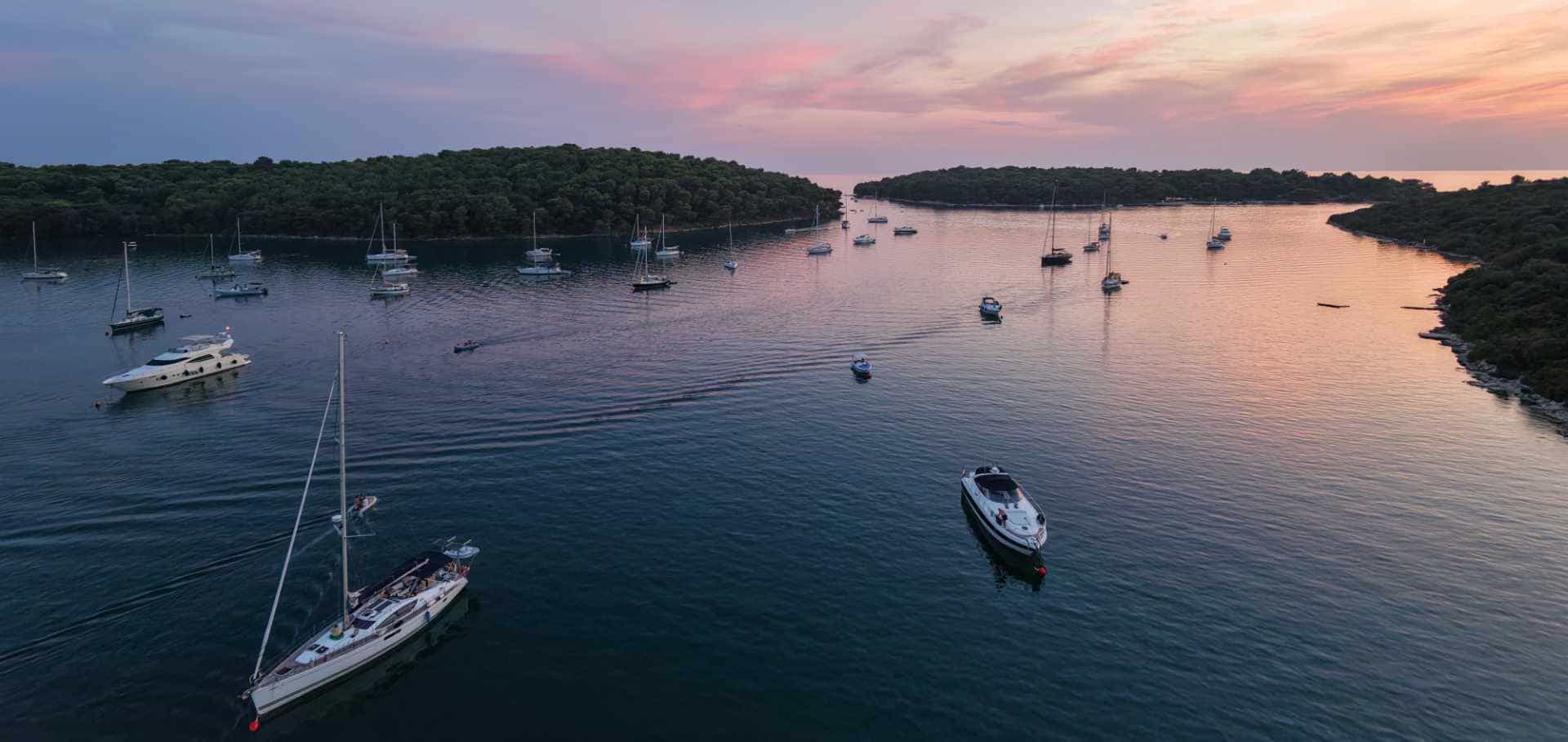 Sailboats anchored at dusk in the Soline bay in Croatia