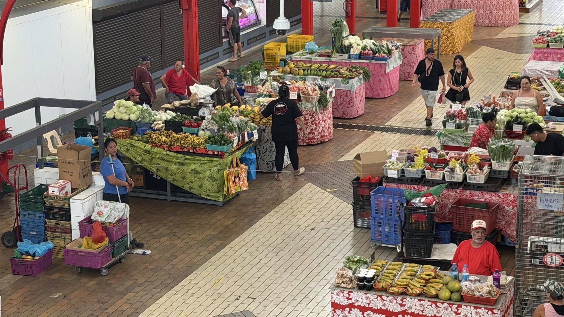 Vibrant fresh fruit and vegetable stands with colorful produce displayed inside the central market hall.