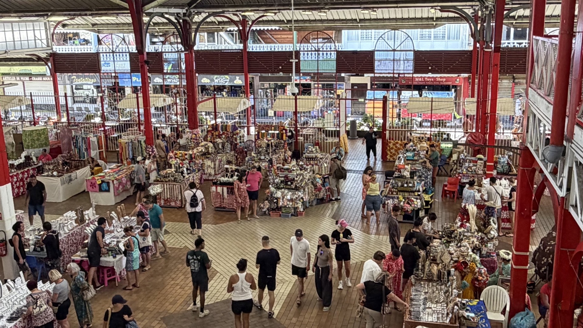 Upper mezzanine level overlooking craft and souvenir shops inside the open-air market structure.