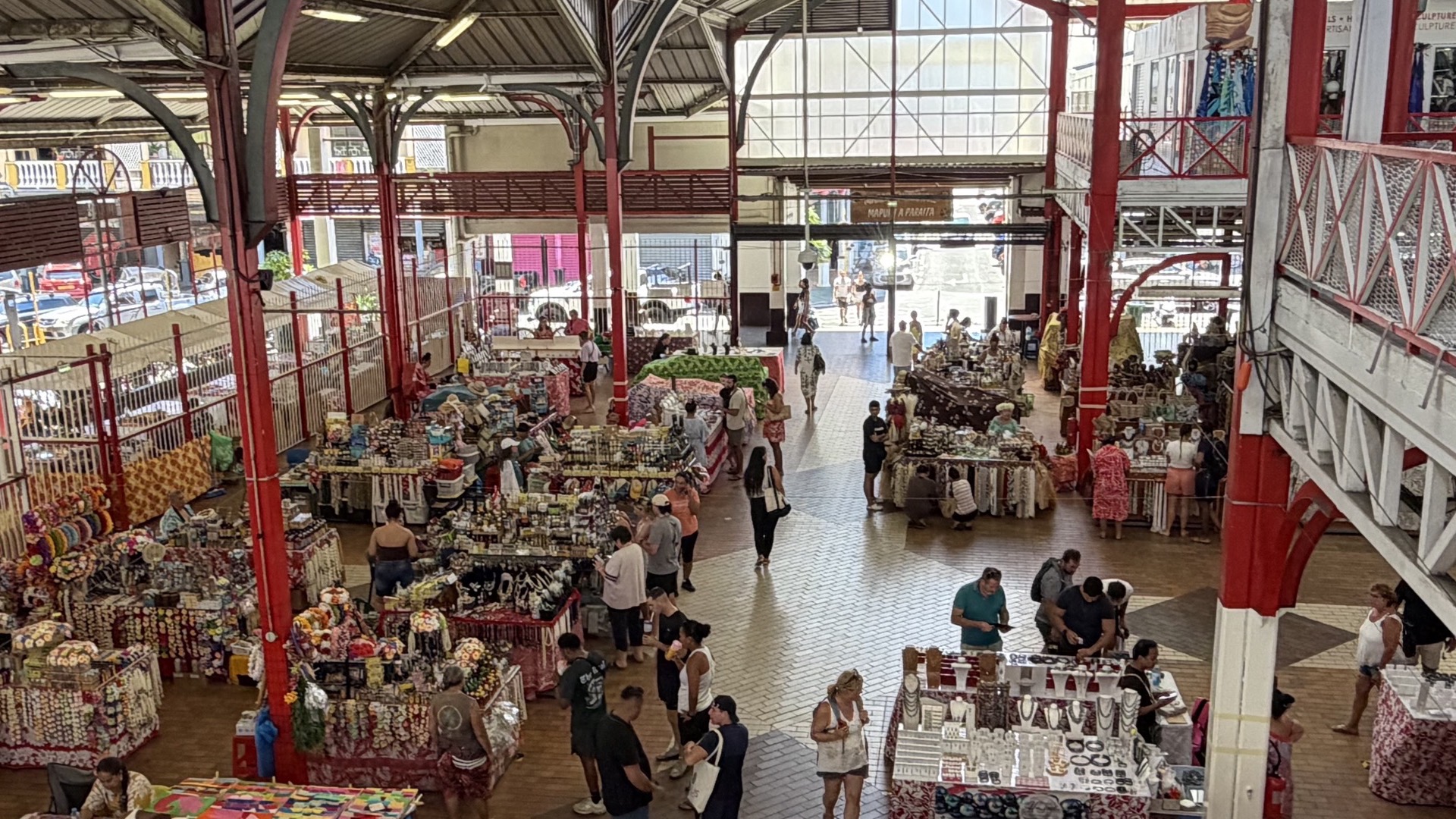 Shoppers browsing diverse local handicrafts, souvenirs, and jewelry stalls on the ground floor.
