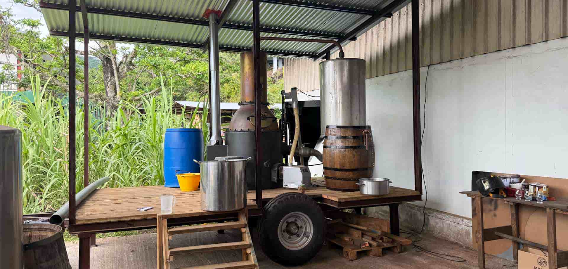 Traditional copper pot distillation equipment set up under an open-air shelter on Taha'a.