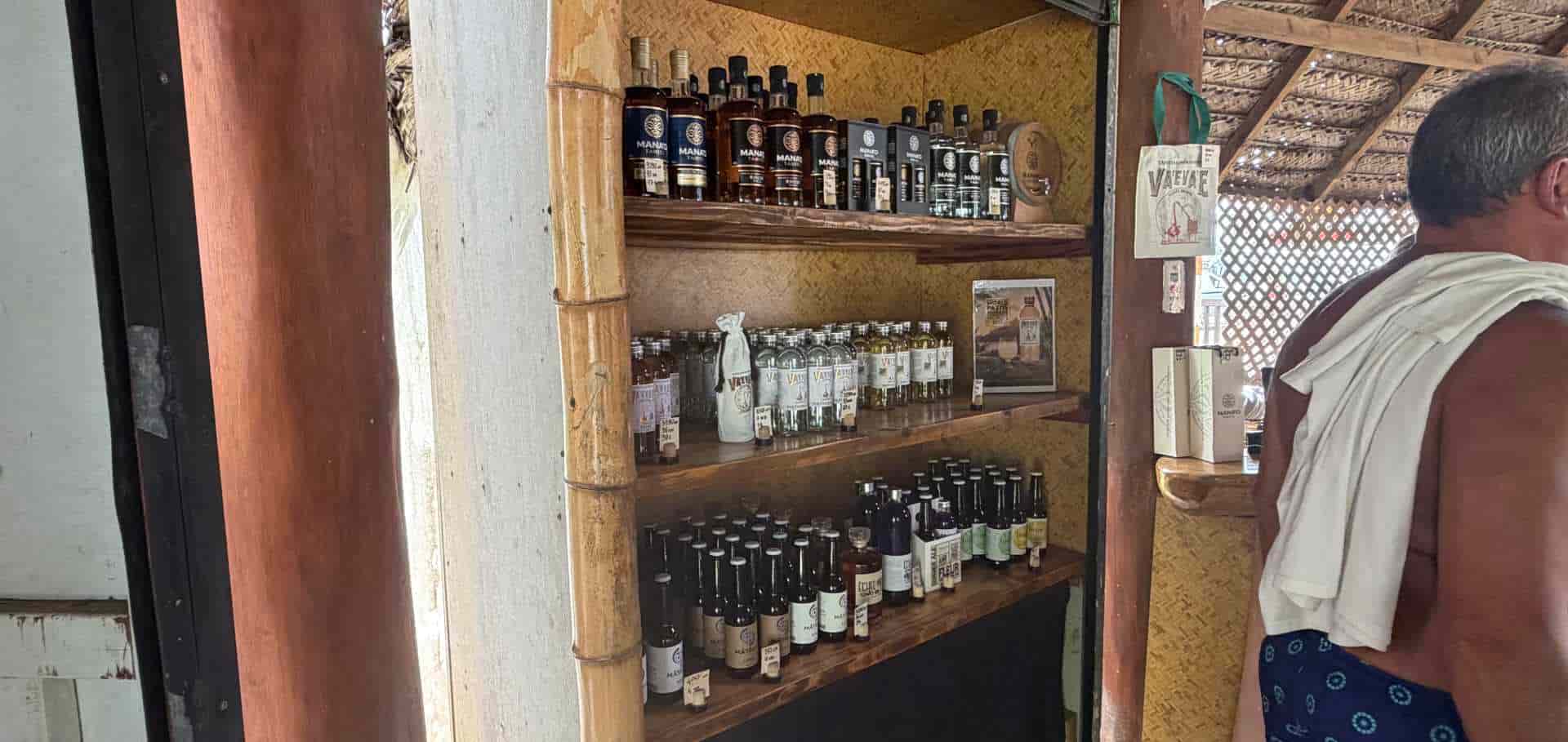 Bottles of Mana'o Tahiti rum and Vaevaie gin lined up on a polished wooden bar counter.