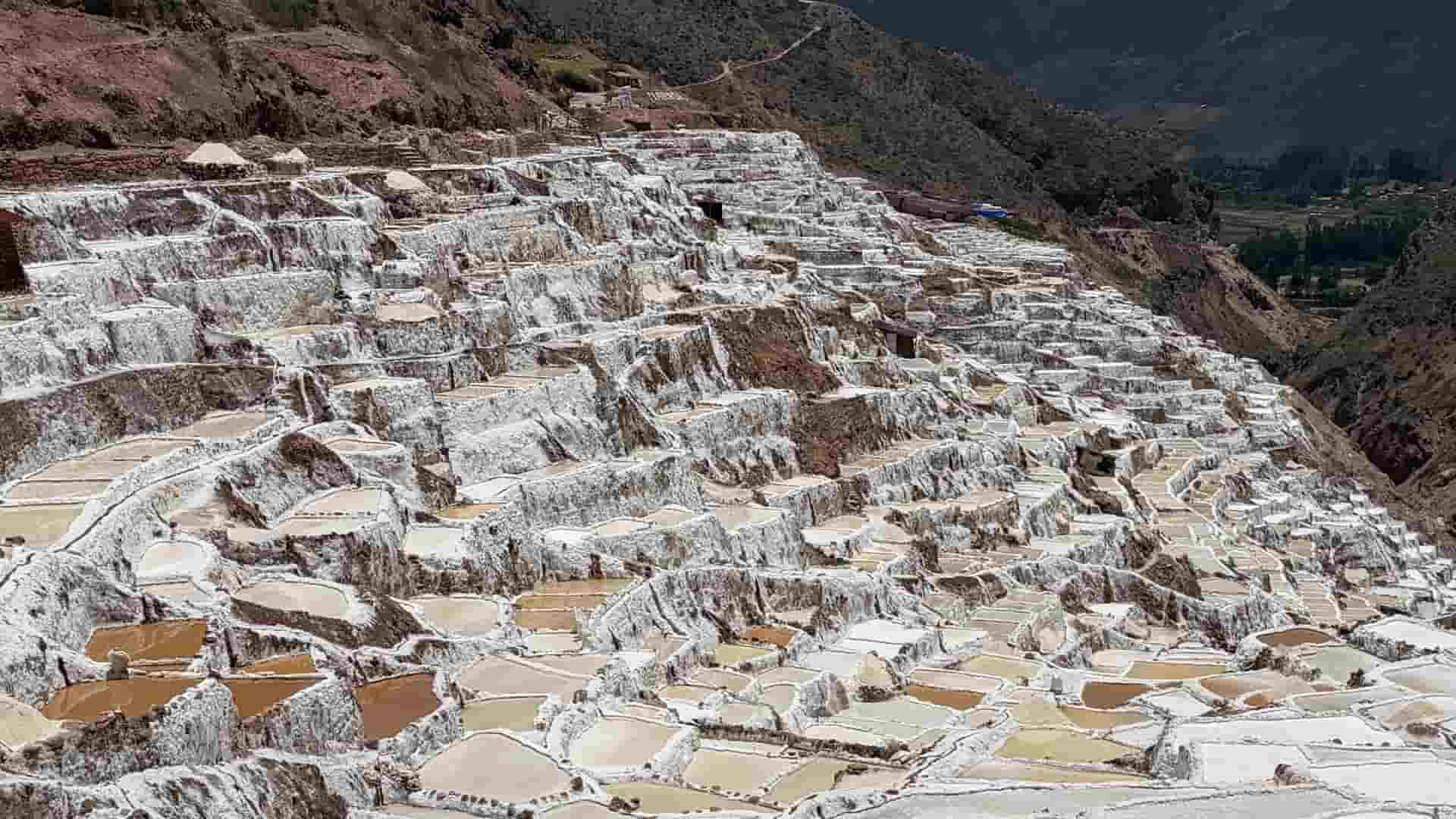 Intricate network of terraced salt pans carved into the red mountain earth.