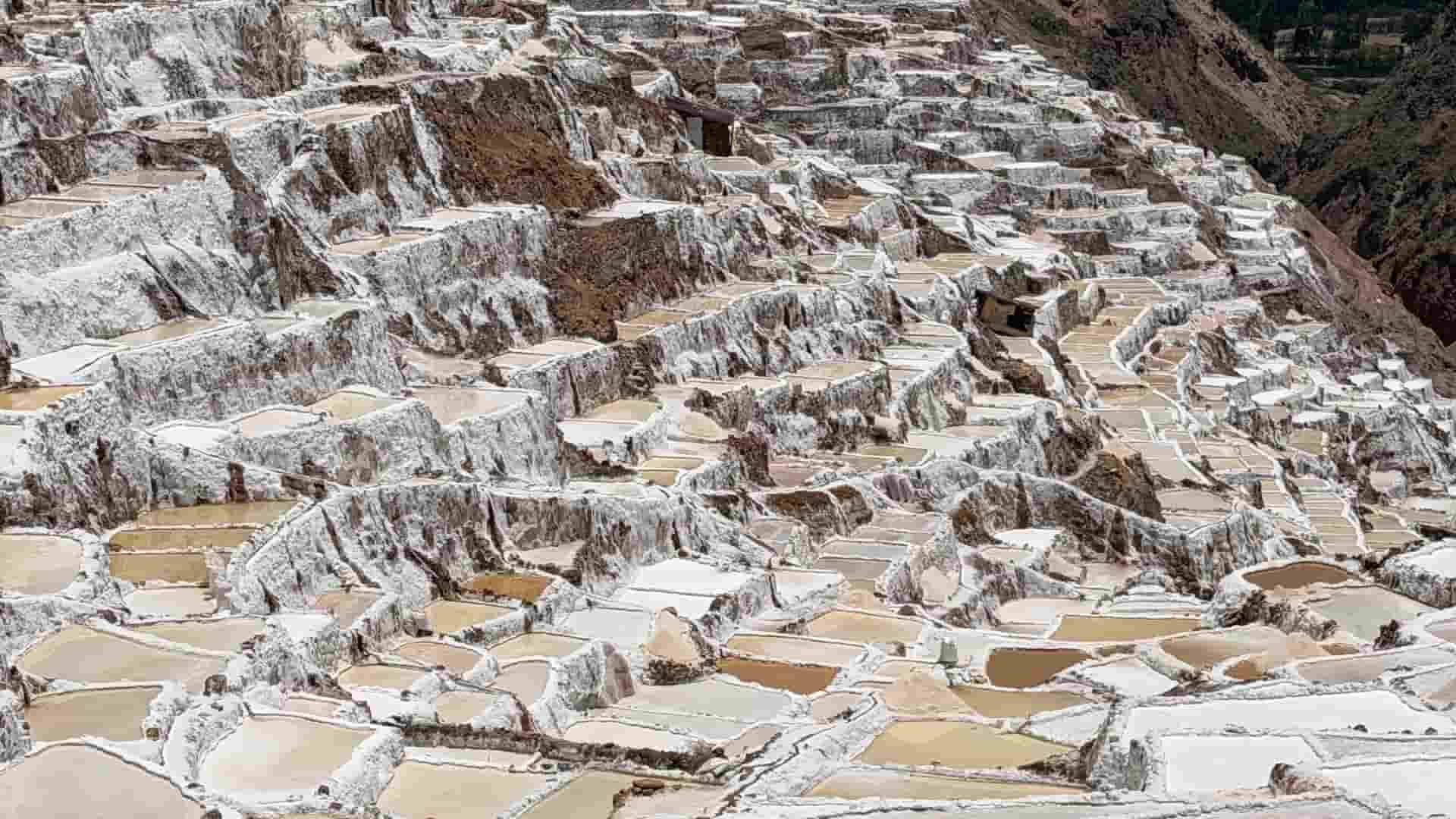 Detailed view of shallow earthen evaporation ponds glistening in the Andean sun.