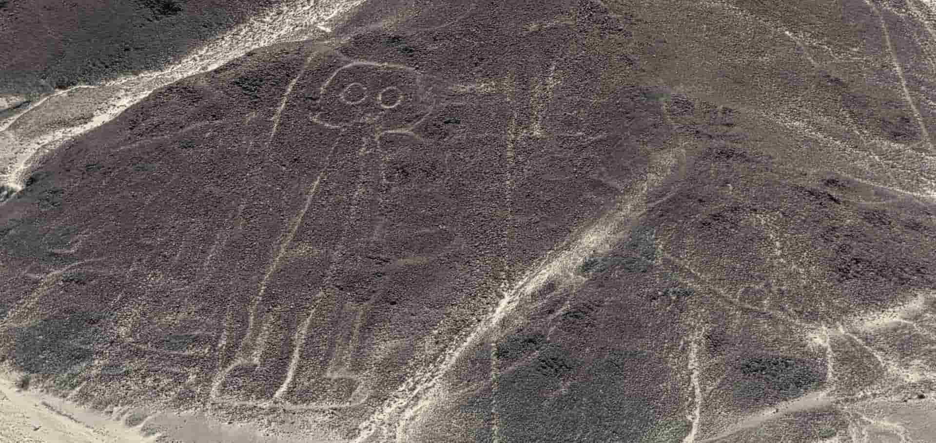 Airplane windowAerial view of the famous astronaut geoglyph etched into the rocky hillside near Nazca.