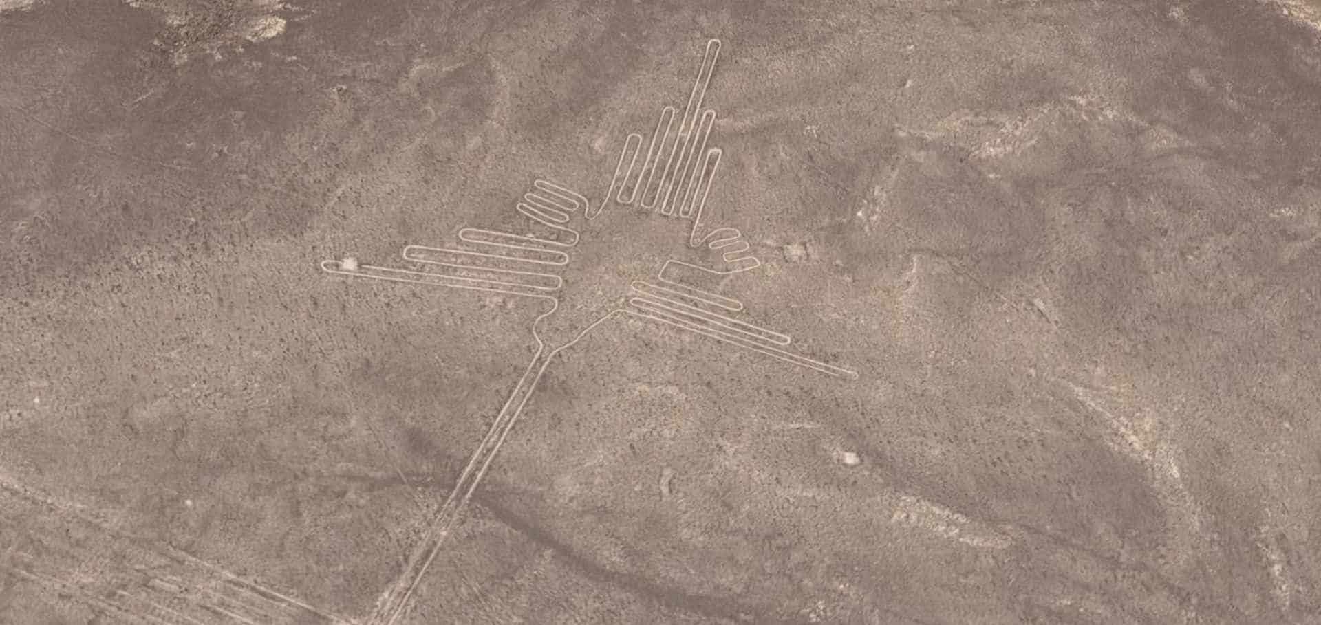 Aerial view of the massive hummingbird geoglyph featuring detailed geometric wings on the plateau.