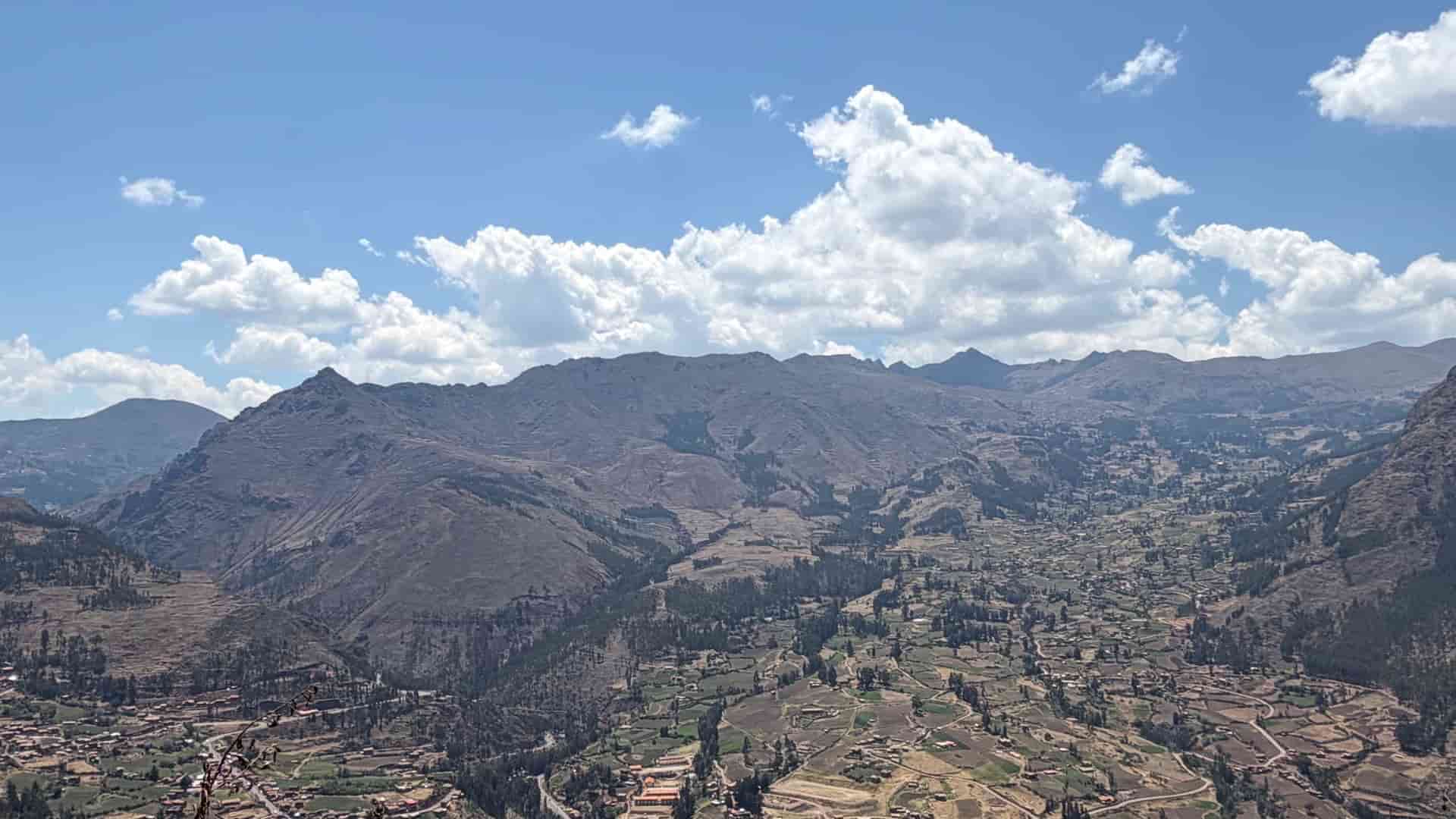 Expansive view of Andean mountain peaks and scattered farming communities below.