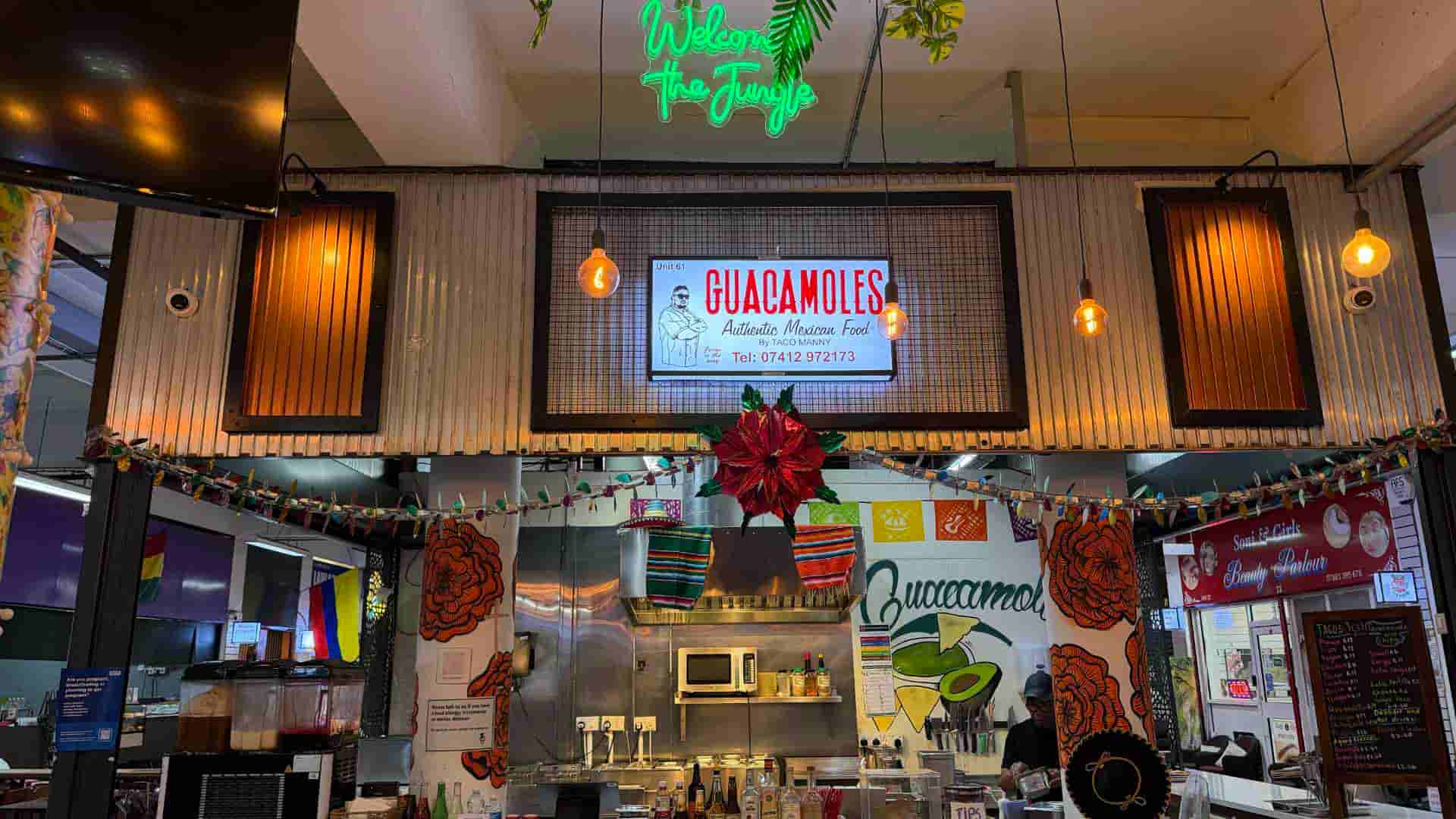 Overhead view of the bustling Guacamoles counter featuring colorful hanging banners.