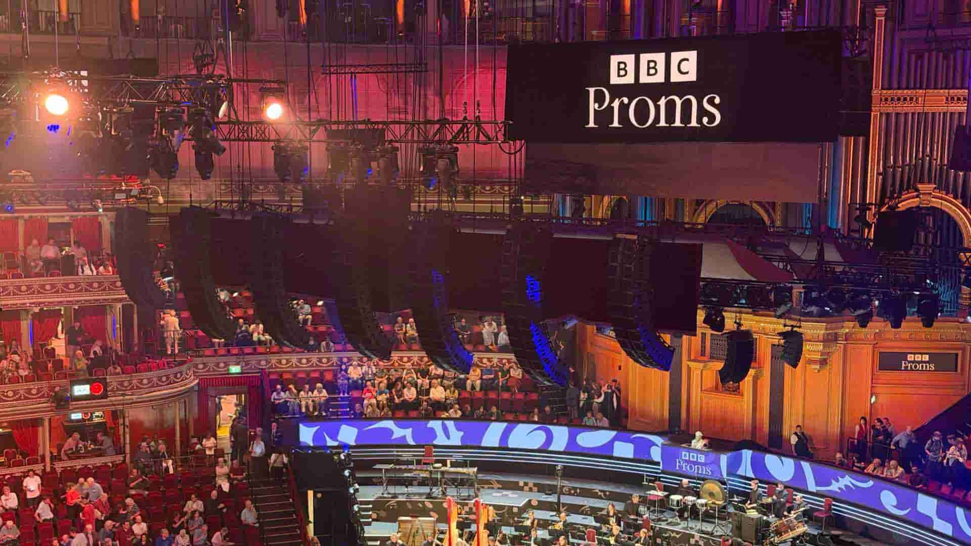 Suspended array of audio speakers hanging above the stage and audience inside the grand concert hall