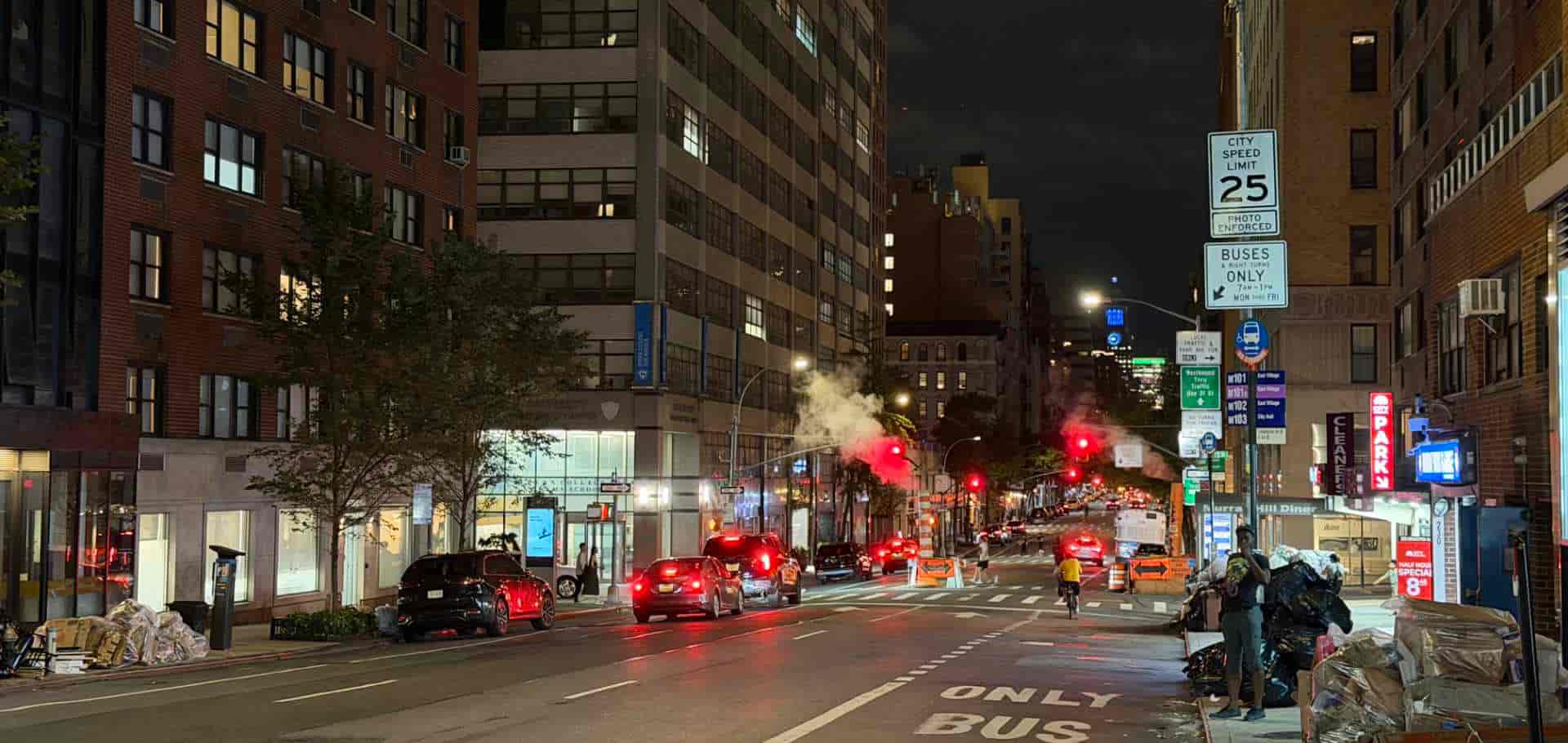 Evening street view in Manhattan with steam rising from underground district utility lines