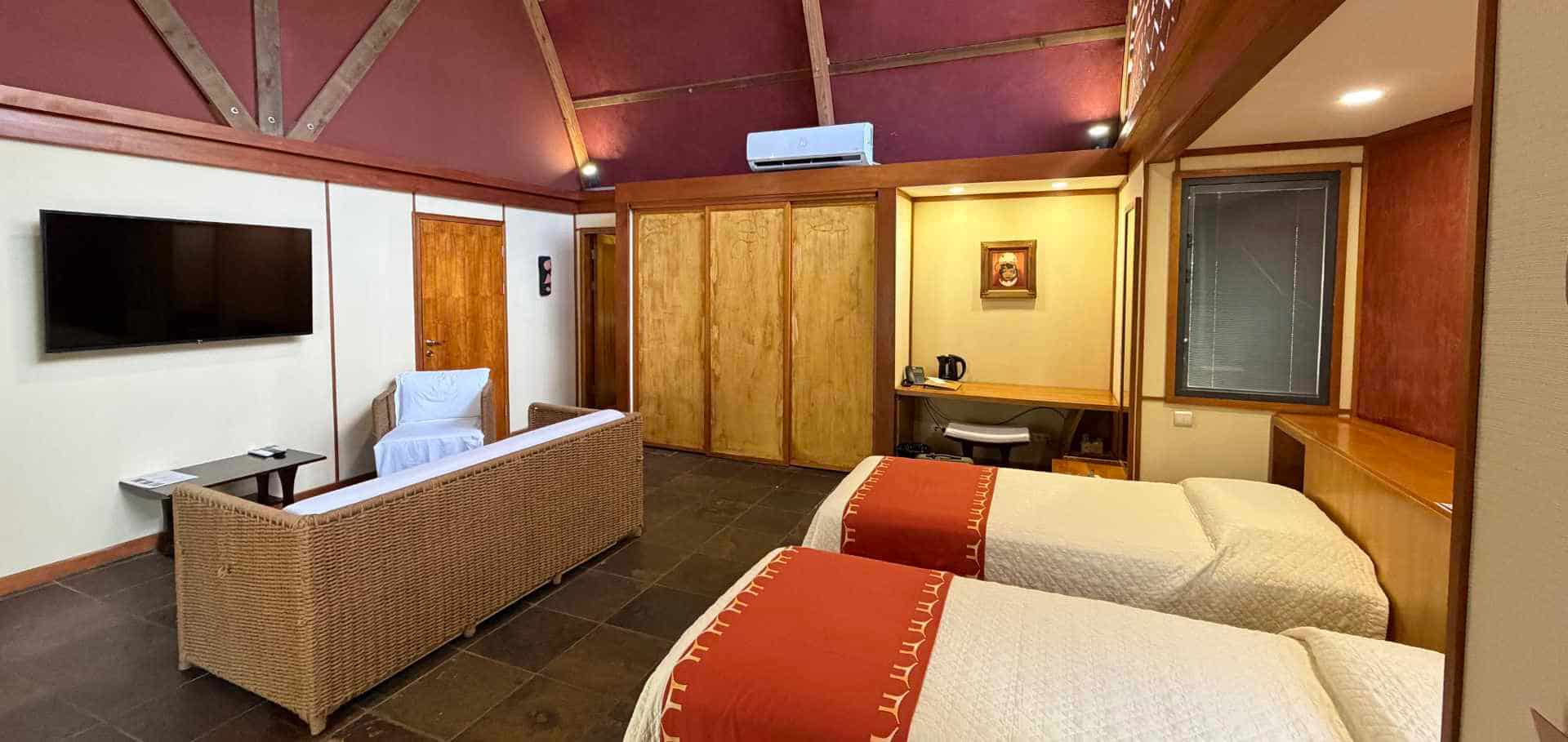 Spacious hotel bungalow bedroom with twin beds and modern amenities.