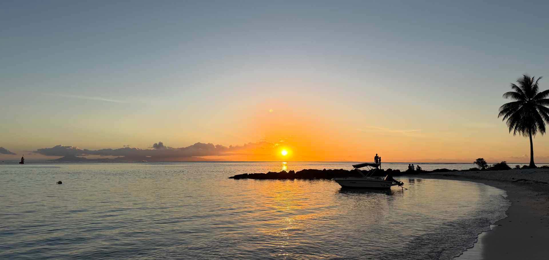 Scenic tropical sunset over the calm sea and beach in Huahine.
