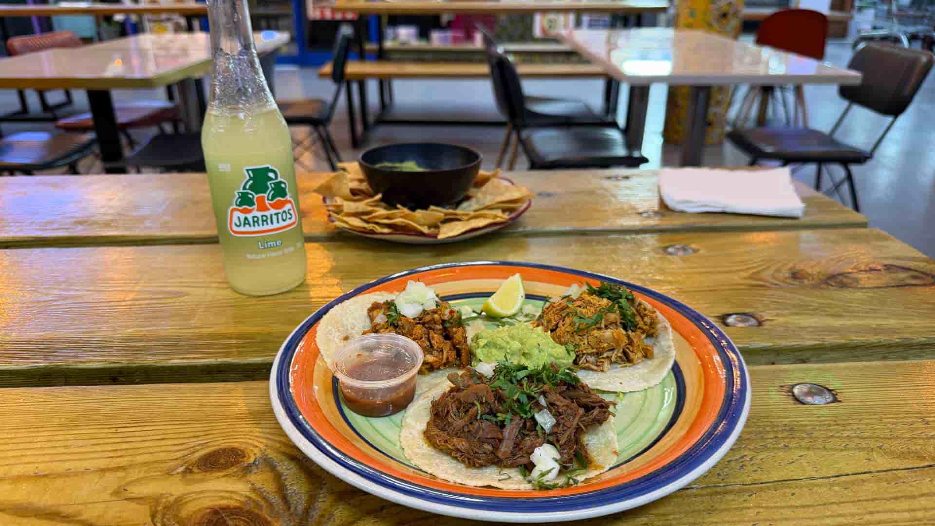 Colorful plate of traditional Mexican tacos paired with ice-cold Jarritos lime soda.