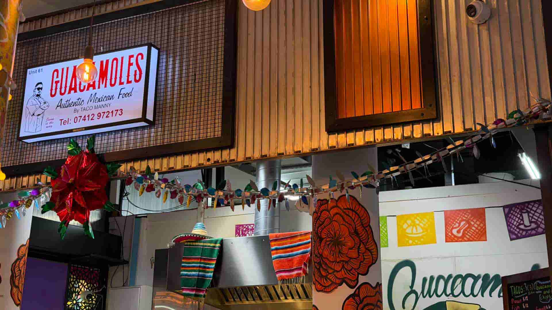 Illuminated storefront sign for Guacamoles authentic Mexican food by Taco Manny.