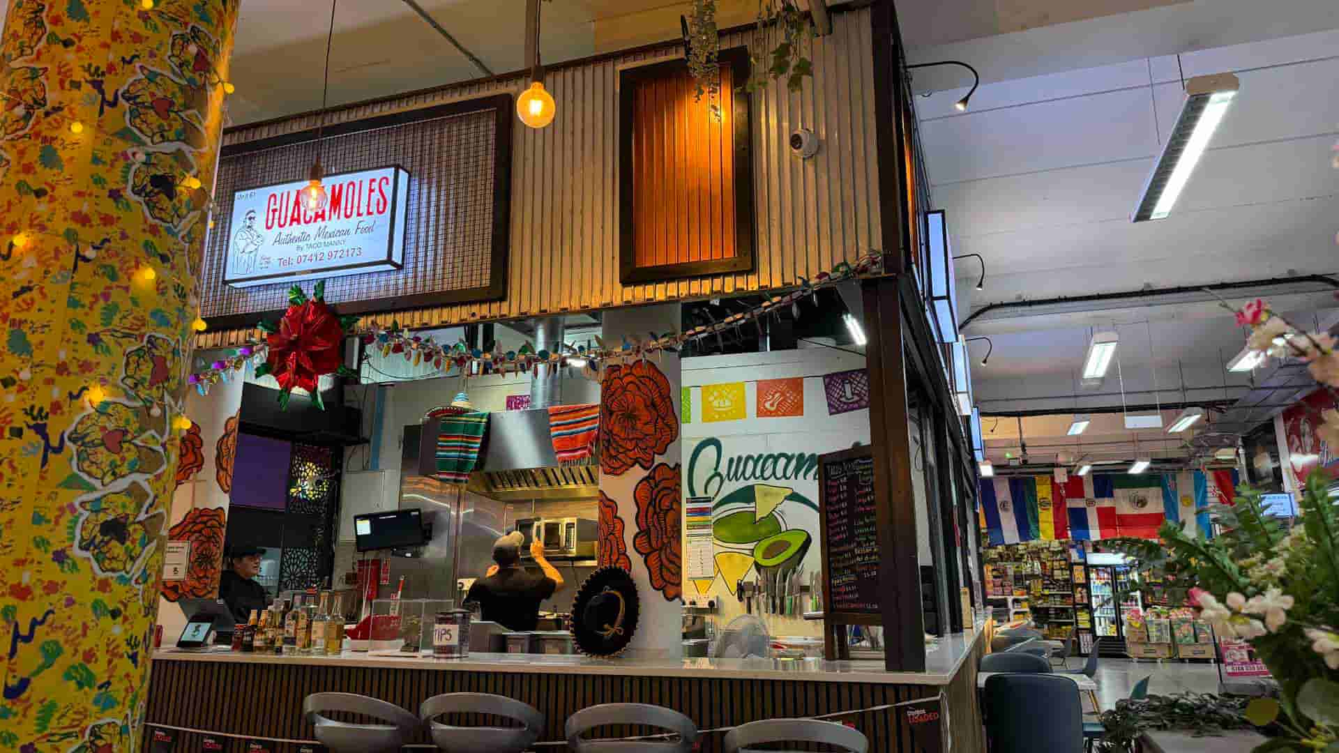 Bustling kitchen counter and decorative seating inside the Peckham food market stall.