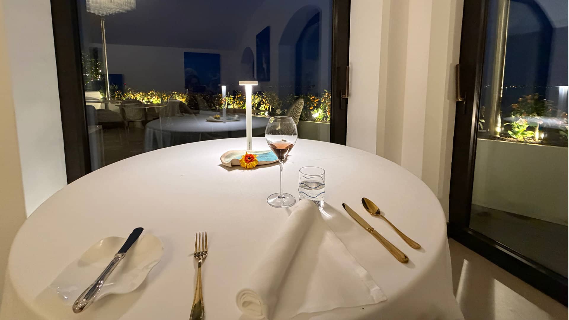 Elegant dining table setup overlooking the glowing night view of Vico Equense.