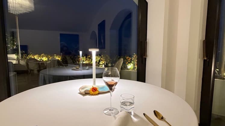 Elegant dining table setup overlooking the glowing night view of Vico Equense.